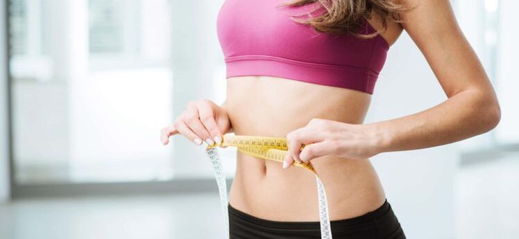 La ragazza misura la vita con un centimetro